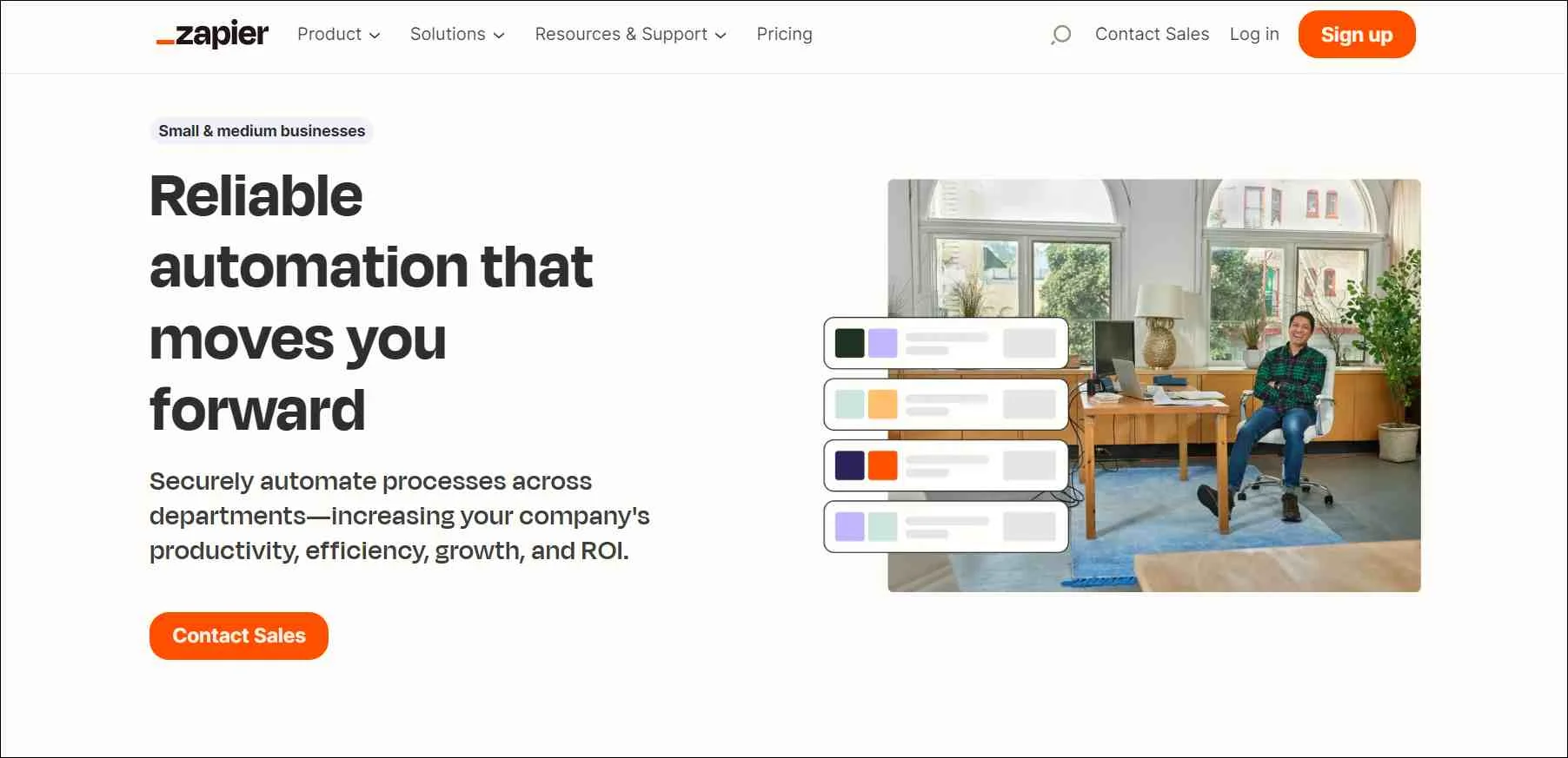Zapier webpage for SMBs highlighting reliable automation, featuring contact sales button and bright office desk image.