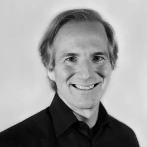 Professional headshot of a person wearing a dark shirt.